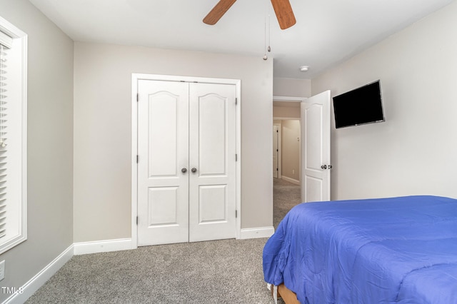 carpeted bedroom featuring ceiling fan and a closet