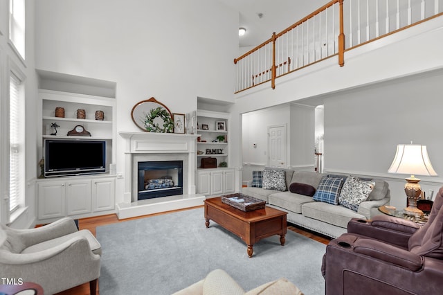 living room featuring a high ceiling, a wealth of natural light, and a fireplace