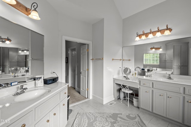 bathroom with vanity, tile patterned flooring, and vaulted ceiling