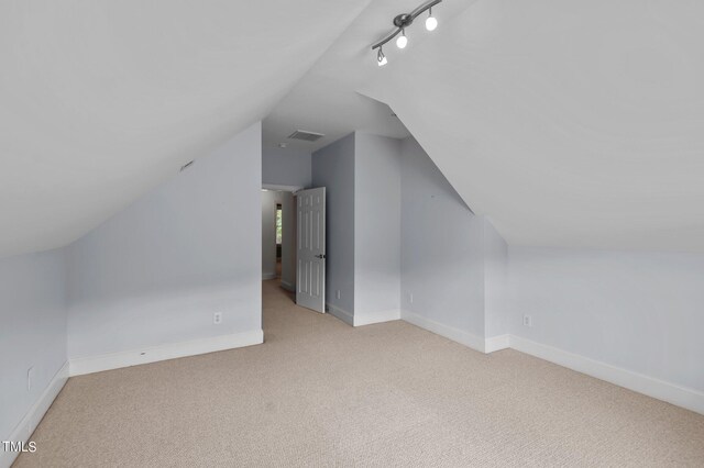 bonus room with light carpet and lofted ceiling