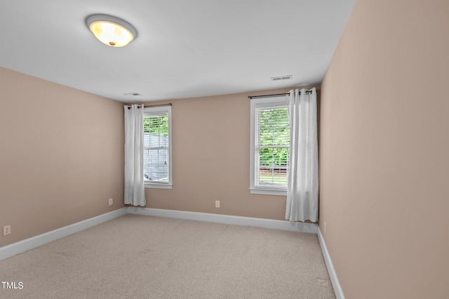 unfurnished room with a healthy amount of sunlight and light colored carpet