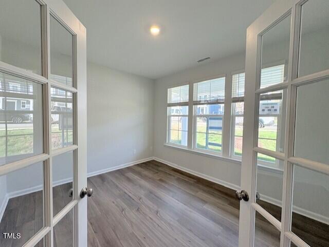 unfurnished room featuring french doors and hardwood / wood-style flooring