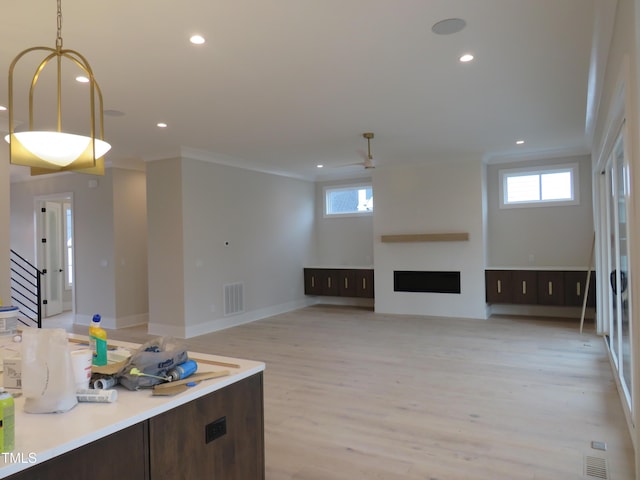 unfurnished living room with ornamental molding and light wood-type flooring