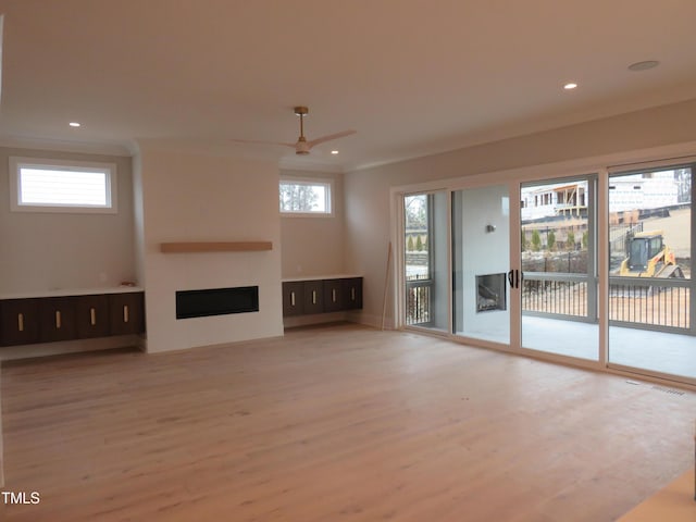 unfurnished living room featuring ceiling fan, plenty of natural light, and hardwood / wood-style floors