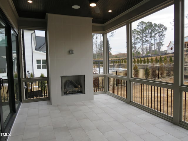 unfurnished sunroom with a tiled fireplace