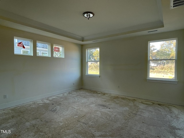 unfurnished room with a raised ceiling and baseboards