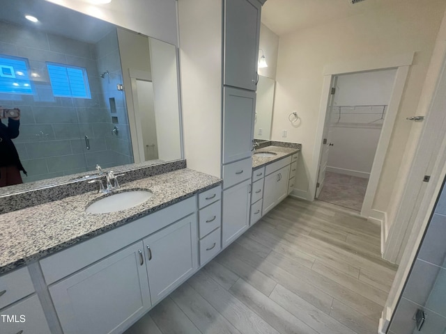 bathroom featuring vanity, wood-type flooring, and walk in shower