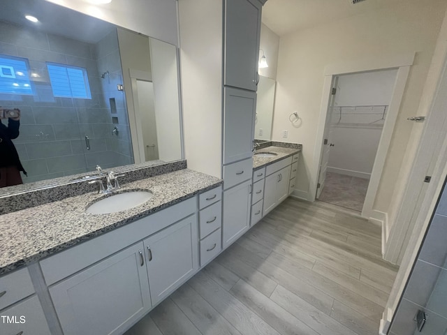 1504 Maelyn Way, Fuquay Varina, NC 27526 - full bathroom with a shower stall, wood finished floors, two vanities, and a spacious closet