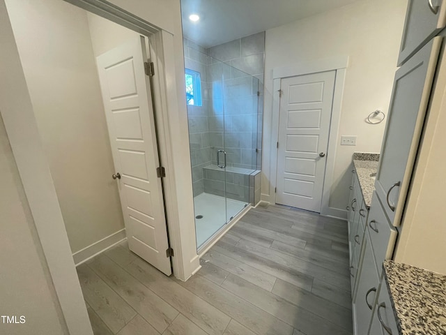 bathroom with hardwood / wood-style floors, vanity, and walk in shower