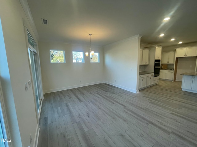 kitchen featuring double oven, crown molding, decorative light fixtures, light hardwood / wood-style flooring, and white cabinetry