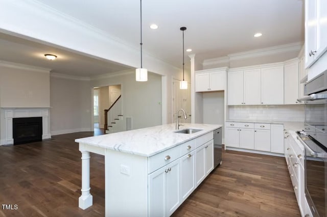 kitchen with a kitchen island with sink, sink, dark hardwood / wood-style flooring, and white cabinetry