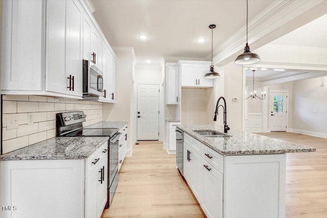 kitchen featuring sink, an island with sink, white cabinets, hanging light fixtures, and stainless steel appliances