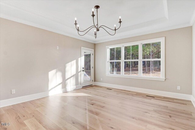 unfurnished room with crown molding, light hardwood / wood-style flooring, and a notable chandelier