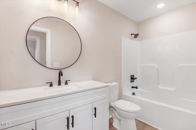 full bathroom featuring vanity, hardwood / wood-style floors, tub / shower combination, and toilet