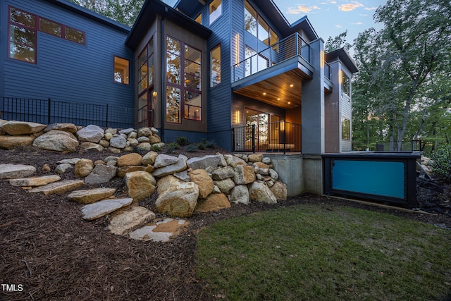 view of side of home featuring a balcony and a swimming pool