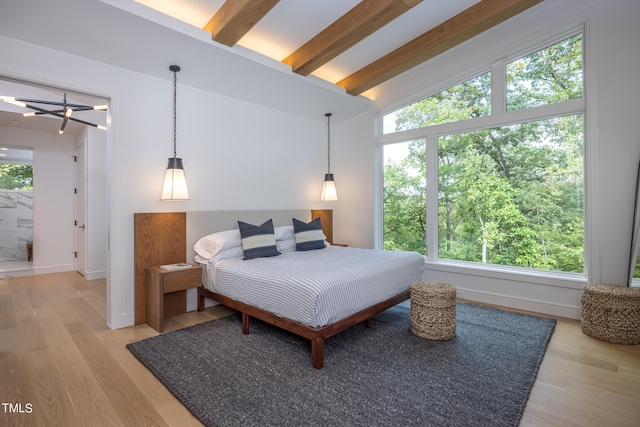 bedroom with wood-type flooring and vaulted ceiling with beams