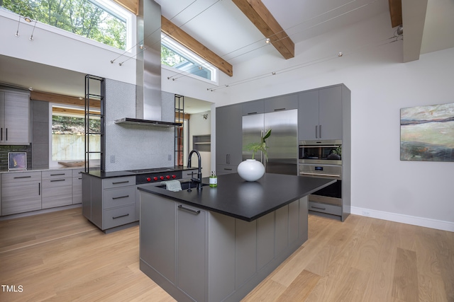 kitchen featuring beamed ceiling, sink, high quality fridge, a kitchen island, and gray cabinets