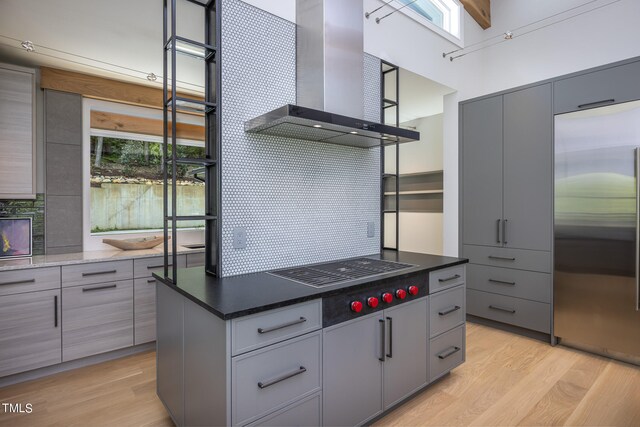 kitchen featuring ventilation hood, built in fridge, light hardwood / wood-style flooring, and gray cabinets