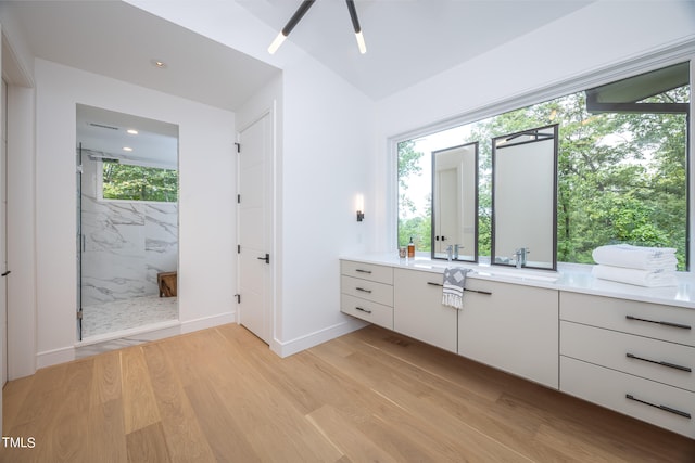 bathroom featuring ceiling fan, hardwood / wood-style flooring, vanity, and tiled shower