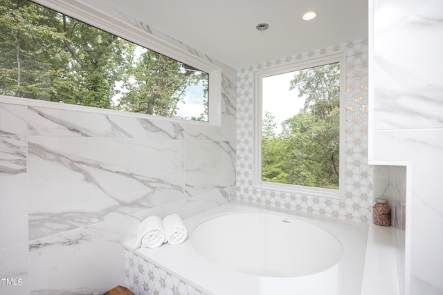 bathroom featuring tile walls and a relaxing tiled tub