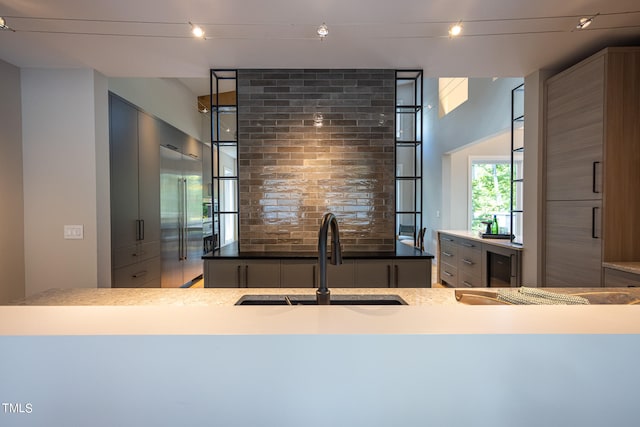 kitchen with backsplash, kitchen peninsula, wine cooler, and sink