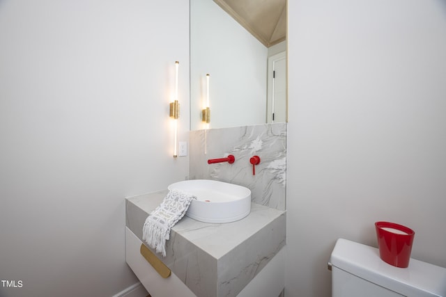 bathroom featuring vanity, lofted ceiling, and toilet