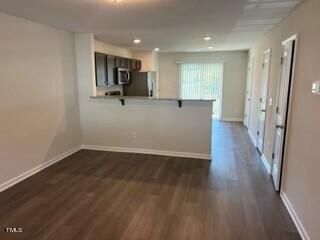 kitchen with kitchen peninsula, dark hardwood / wood-style floors, and appliances with stainless steel finishes