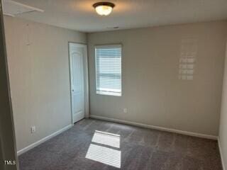 empty room featuring dark colored carpet