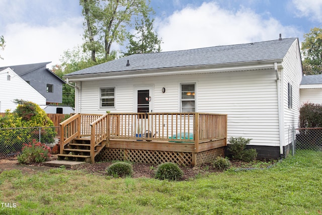 back of house featuring a lawn and a deck