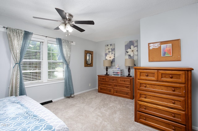 carpeted bedroom featuring a textured ceiling and ceiling fan