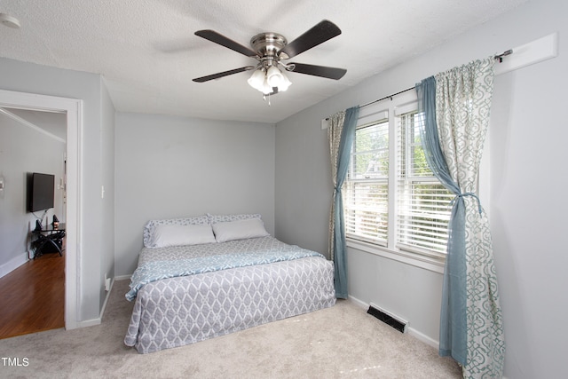 bedroom featuring ceiling fan, carpet flooring, and a textured ceiling