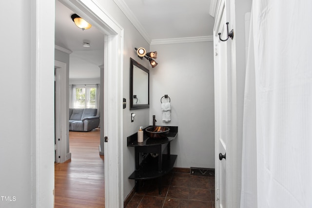 bathroom with hardwood / wood-style flooring, crown molding, and sink