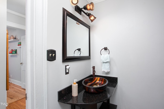 bathroom with hardwood / wood-style flooring, sink, and ornamental molding