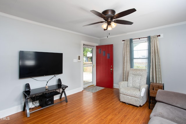 living room featuring a healthy amount of sunlight, wood-type flooring, and crown molding