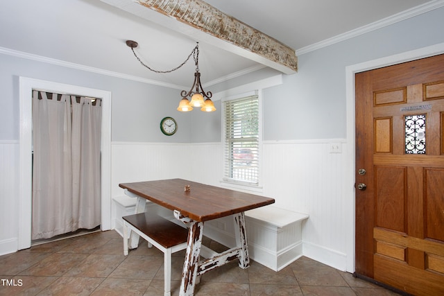 dining area featuring a chandelier, ornamental molding, and tile patterned flooring