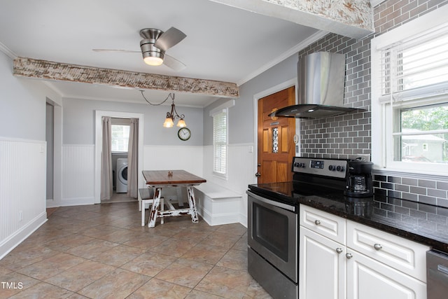 kitchen featuring white cabinets, tasteful backsplash, wall chimney range hood, washer / dryer, and electric stove