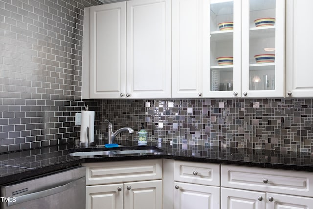 kitchen featuring decorative backsplash, stainless steel dishwasher, sink, and white cabinets