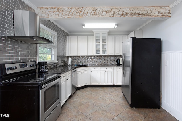 kitchen featuring wall chimney exhaust hood, stainless steel appliances, white cabinetry, and backsplash