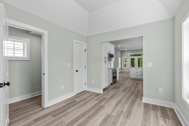 spare room with light wood-type flooring and plenty of natural light