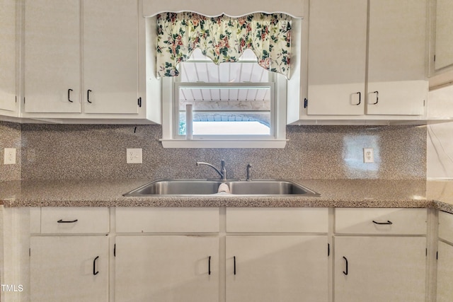 kitchen with sink, tasteful backsplash, and white cabinetry