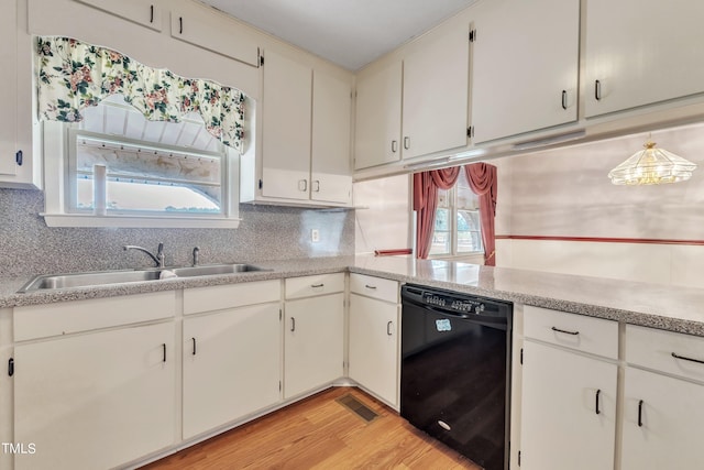 kitchen featuring black dishwasher, light hardwood / wood-style flooring, sink, and tasteful backsplash