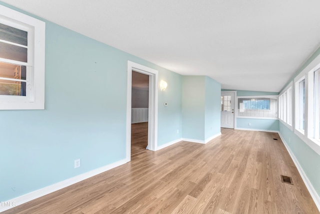 unfurnished living room with light hardwood / wood-style flooring and lofted ceiling