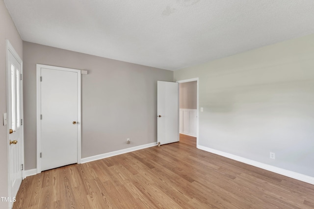 interior space featuring a textured ceiling and light hardwood / wood-style flooring