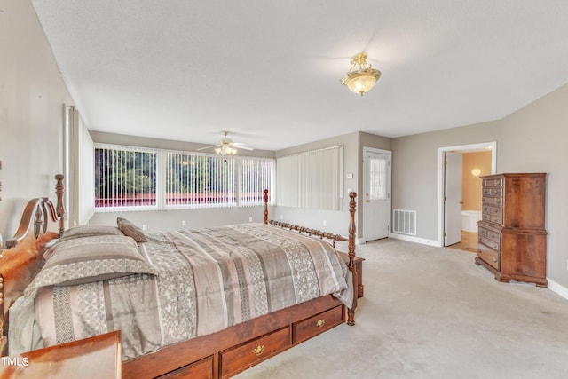 bedroom featuring ceiling fan, connected bathroom, and light carpet