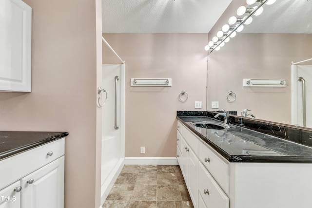 bathroom with a textured ceiling and vanity