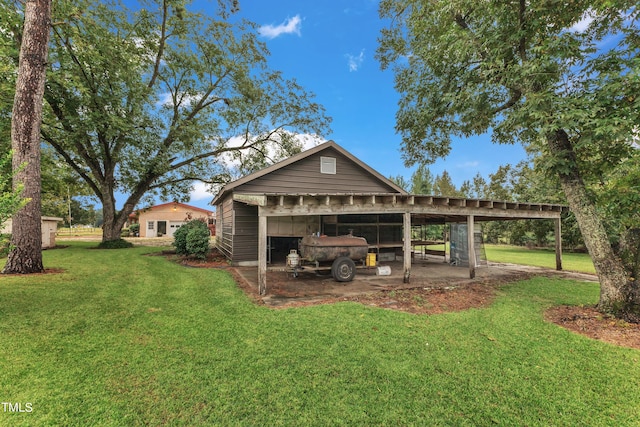 back of house featuring a carport and a yard