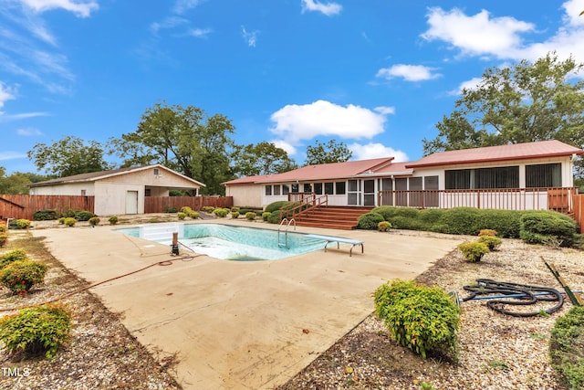 view of swimming pool with a sunroom, a patio area, and a diving board