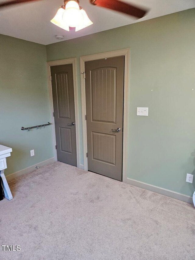 interior space with carpet flooring and ceiling fan