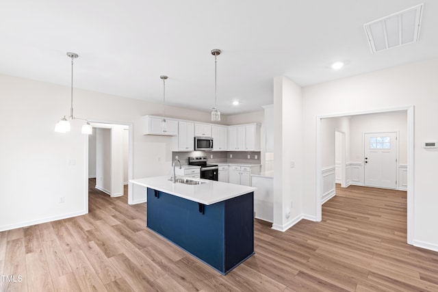 kitchen featuring white cabinetry, sink, hanging light fixtures, a kitchen island with sink, and stainless steel appliances