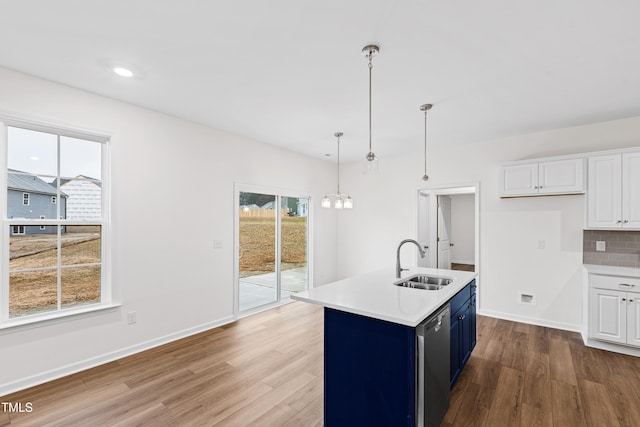 kitchen with sink, dishwasher, a kitchen island with sink, hanging light fixtures, and white cabinets